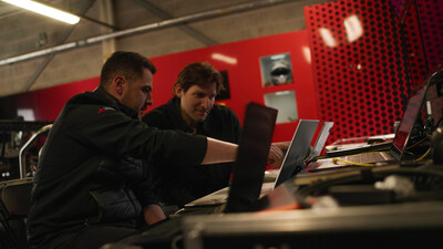 Adam Feiler, Head of Partnerships at Minima, and Oliver Plucknett, Race Lab team manager, discussing the integration of the data logger with the McLaren race cars